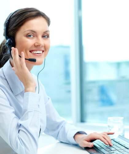 Portrait of young operator with headset looking at camera with friendly smile